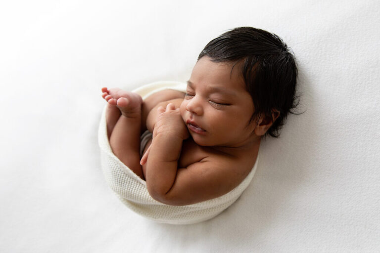 Newborn photography taken in darwin of newborn baby in white black hair