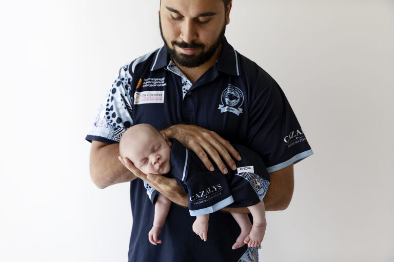 man holding newborn baby in arms
