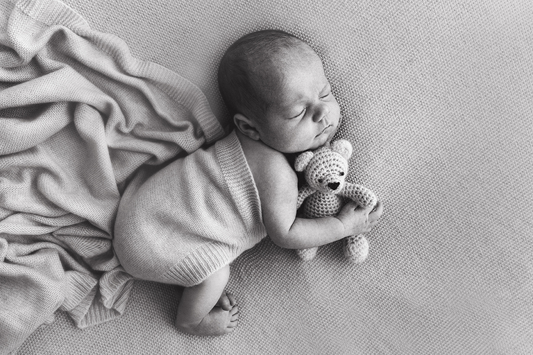Darwin newborn photograph lying on side with teddy
